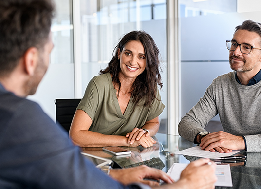 Couple talking to advisor at meeting table