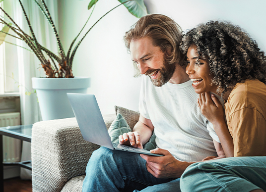 Couple searching on laptop for fixed fees