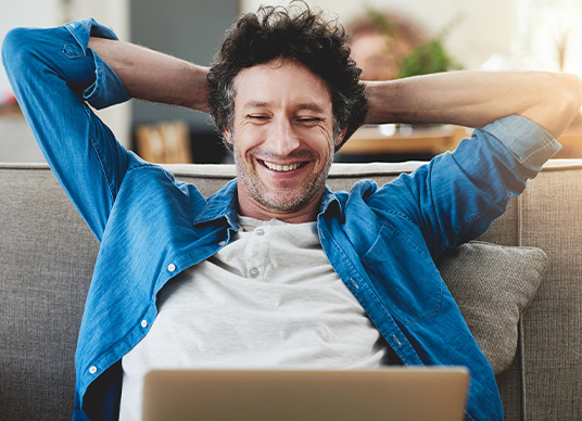 Man relaxing with laptop on couch