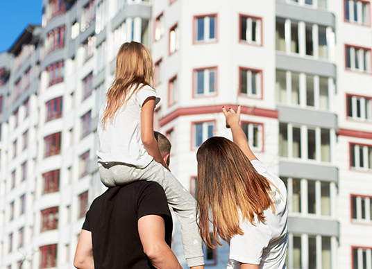 Couple with daughter looking at apartement buildings