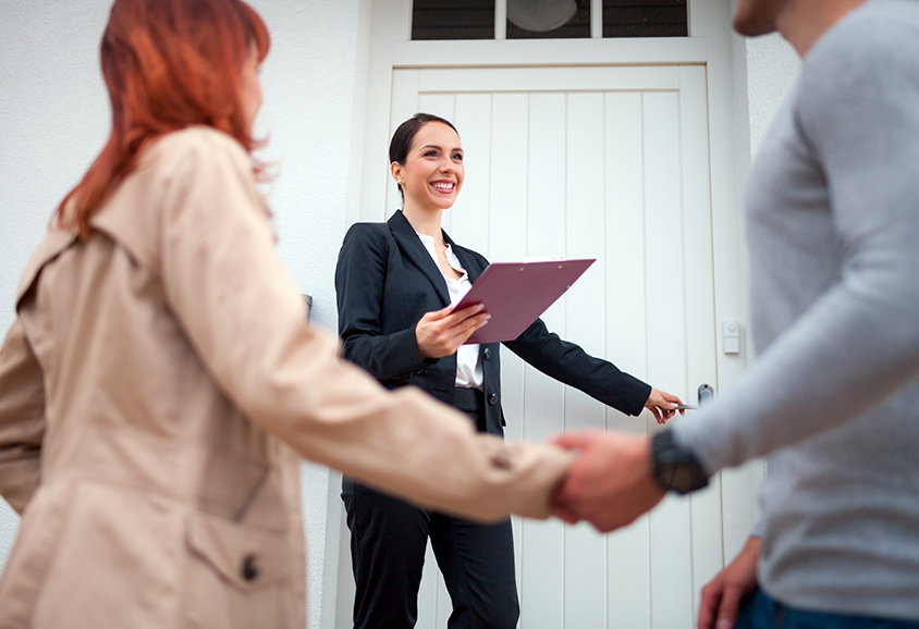 Estate agent showing couple into property